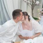 Romantischer Kuss im grünen Garten des Moorhofs – Hochzeitsportraits